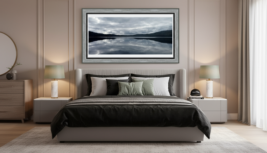 Modern bedroom with a bed, nightstands, and a framed picture of a lake.